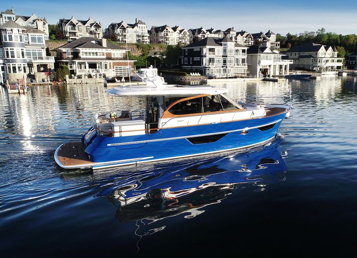 BLUE cruiser on the water with buildings in the distance