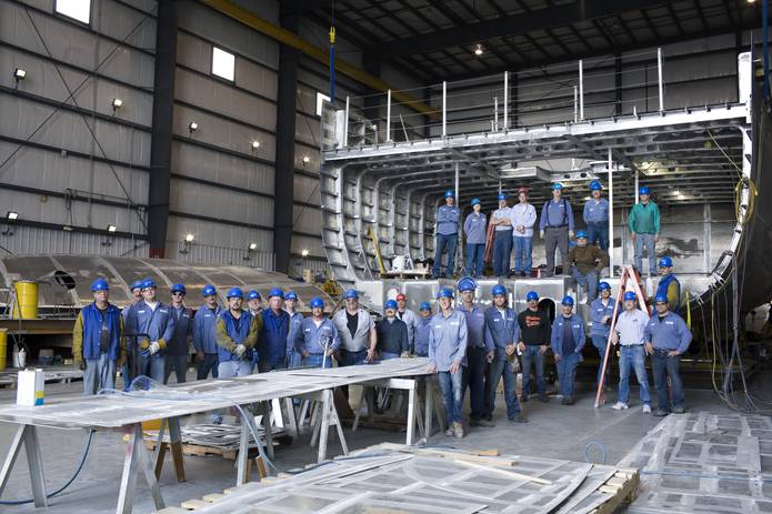Group shot of associates in front of yacht in progress